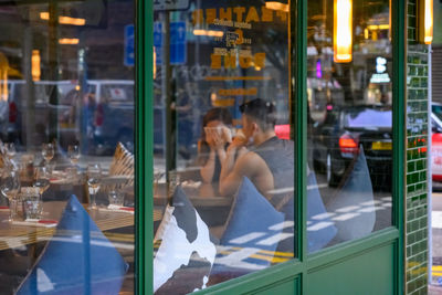 Couple seen through glass window of restaurant