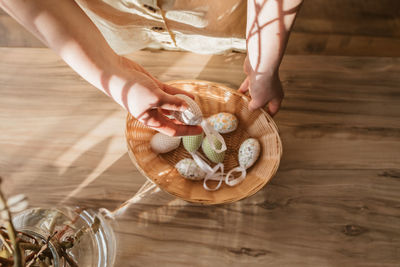 Close-up of a girl's hand taking out easter textile eggs for home decoration. holidays