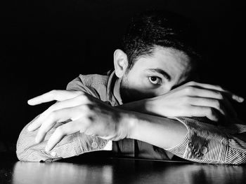 Portrait of young man against black background