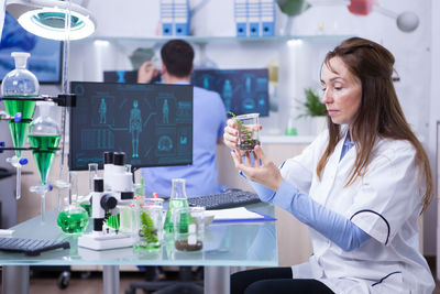 Female dentist and woman working in laboratory