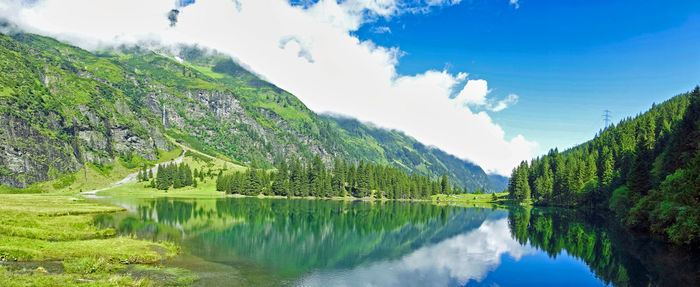 Panoramic view of lake by trees against sky