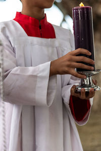 Seminarian carries a seven-day candle on the day of the dead holiday at the campo santo cemetery