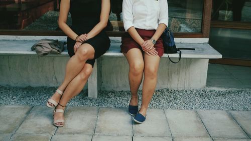 Low section of women sitting outdoors