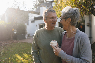 Happy senior couple with cup of coffee in garden