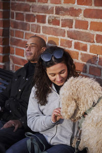 Couple with dog sitting on bench