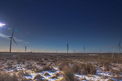 Traditional windmill on field against blue sky