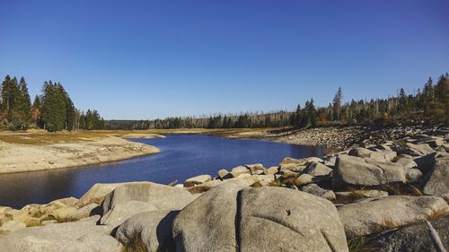 Scenic view of lake against clear blue sky