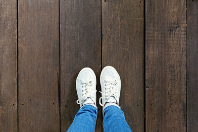 Low section of man standing on hardwood floor