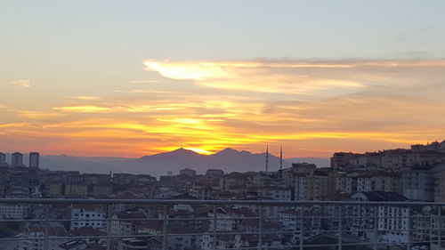 View of cityscape against cloudy sky