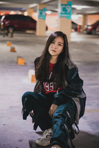 Beautiful young woman sitting in parking lot