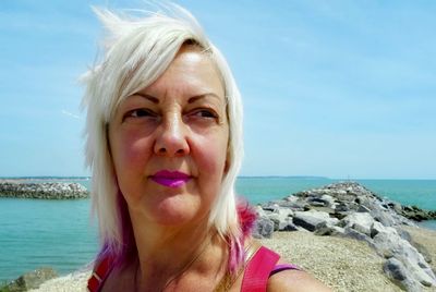 Portrait of woman at beach against sky