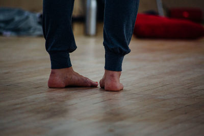 Low section of man standing on floor at home