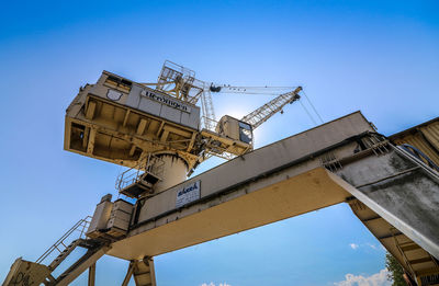 Low angle view of crane against blue sky