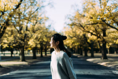 Smiling young woman standing on road