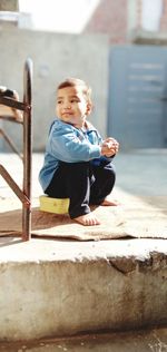 Portrait of cute boy sitting outdoors