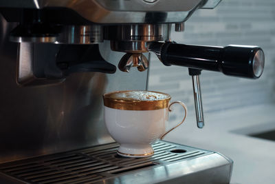 Close-up of coffee cup and espresso machine 