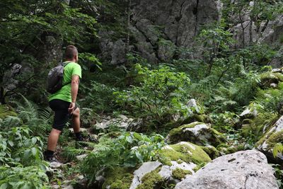 Full length of man on rock in forest