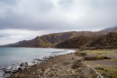 Scenic view of sea and mountains against sky