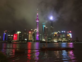 River with illuminated buildings at night