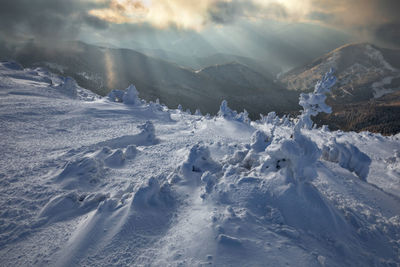 Aerial view of snow covered mountains against sky