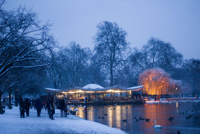 People by lake at public park during winter