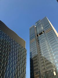 Low angle view of modern buildings against clear blue sky