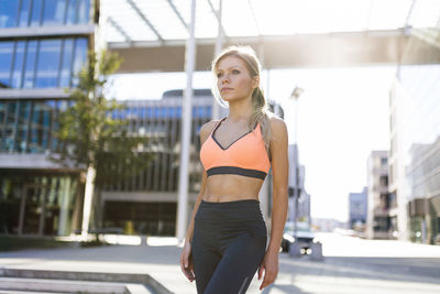 Woman standing on sidewalk in city