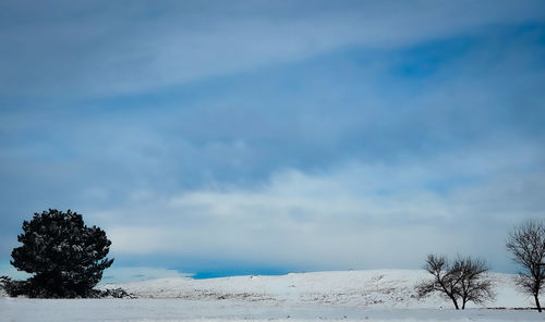 Scenic view of snow covered land against sky