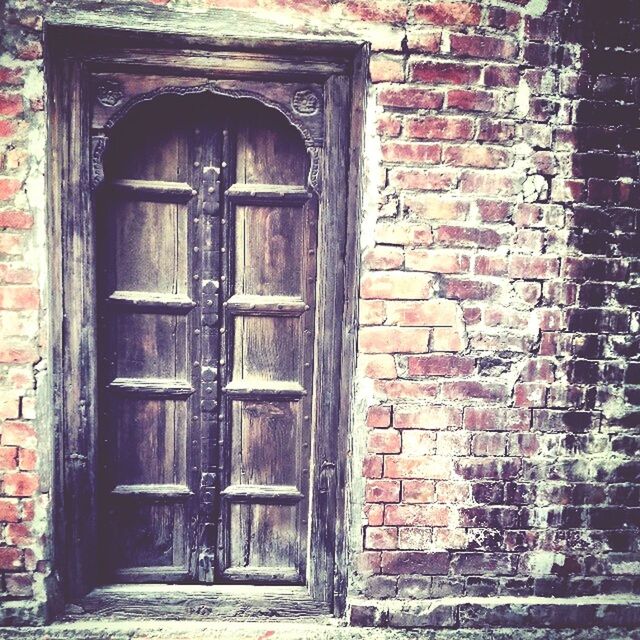 Old wooden door on brick wall