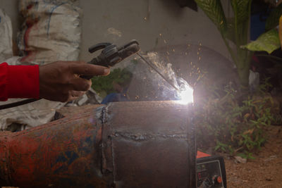 Cropped hand of man welding metal