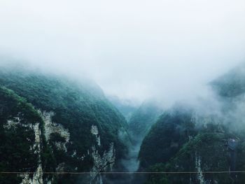 Scenic view of lake in foggy weather against sky