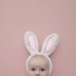 Portrait of cute baby against pink background