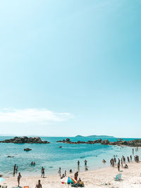 People on beach against sky