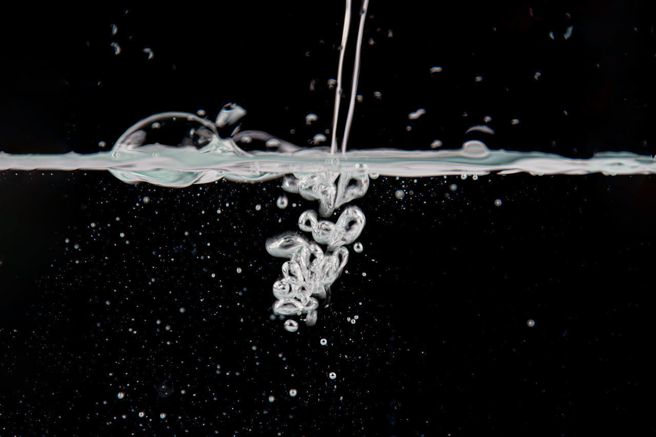 CLOSE-UP OF WATER SPLASHING ON GLASS