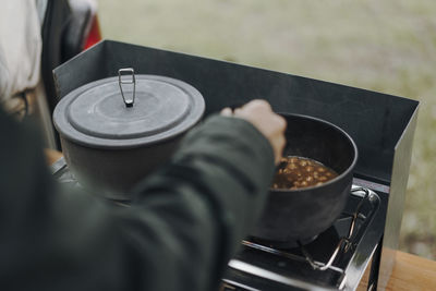 Midsection of man preparing food on barbecue grill