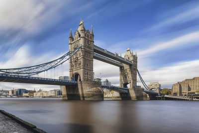 View of bridge over river against cloudy sky