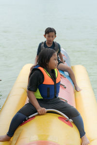 Full length of a smiling boy sitting in water