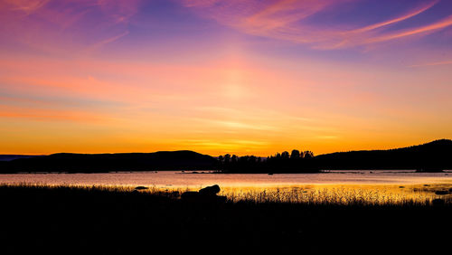 Scenic view of lake against romantic sky at sunset