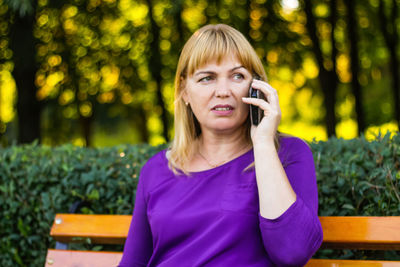 Wonderful caucasian blond woman talking, speaking on the phone outside, outdoor. 40s years old woman