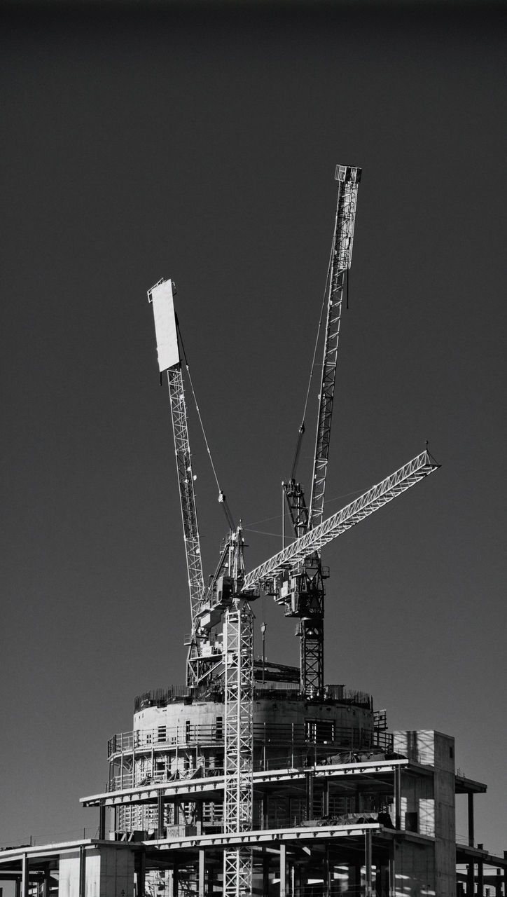 LOW ANGLE VIEW OF CRANE AGAINST BUILDING