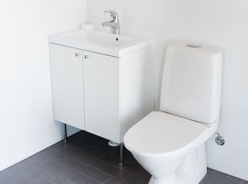 High angle view of toilet bowl by cabinet in bathroom