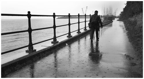 People standing on pier over sea against sky