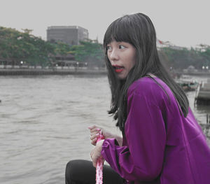 Portrait of young woman holding pink water