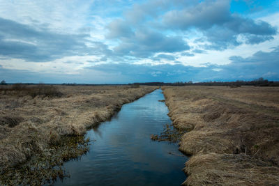 A small river that flows through dry meadows in eastern poland