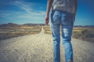 Low section of man standing on road