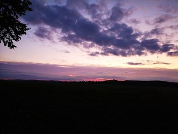 Scenic view of silhouette field against sky at sunset