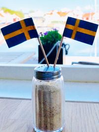 Close-up of drink in glass jar on table with swedish flags