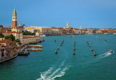 High angle view of buoys on grand canal by cityscape against clear blue sky