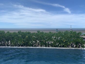 Scenic view of swimming pool by sea against sky