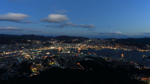 Aerial view of illuminated cityscape against sky at night